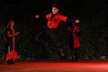 Georgian dancer performing traditional jump on stage